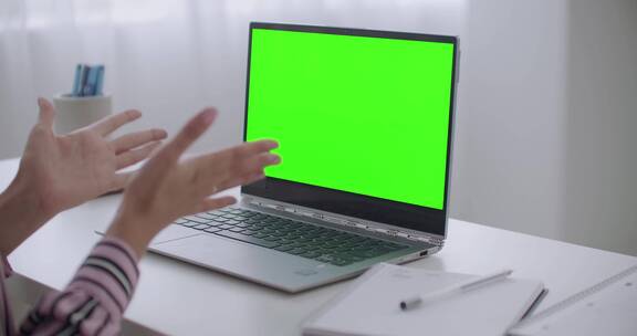 女人在绿色屏幕面前摆弄手势