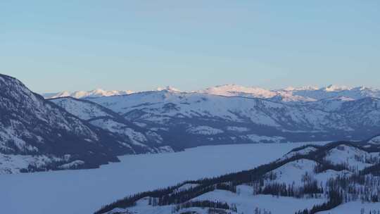 航拍新疆冬季喀纳斯河流晨雾雪山森林雪景