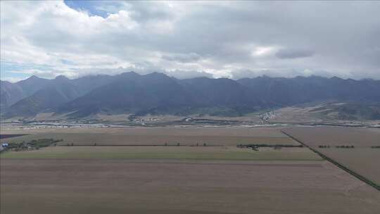 壮观山脉下的广阔田野全景