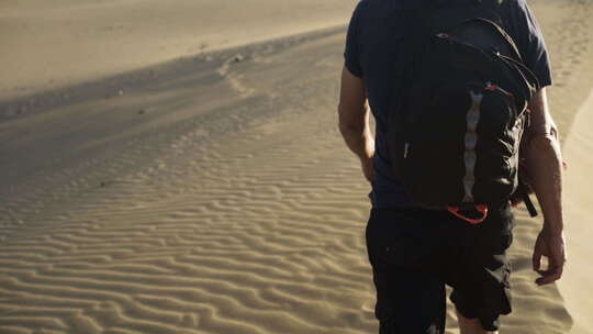 男人走在沙丘上