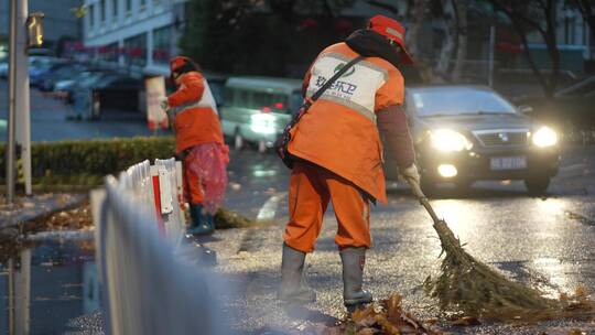 清晨慢镜头记录环卫工人打扫雨后落叶的街道