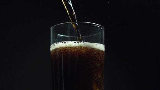 可乐的超级慢动作剪辑被倒入玻璃杯中
