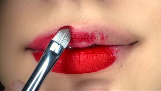 模特用刷子在嘴唇上涂上红色的膏体视频素材模板下载