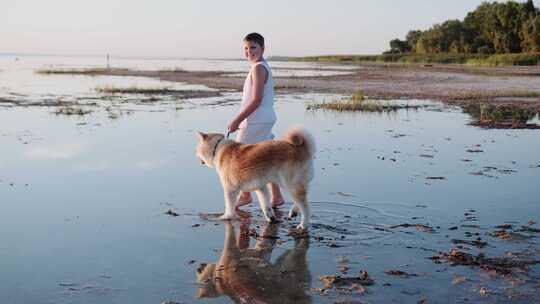 在湖边散步时，快乐的小抱着一条皮带上的秋