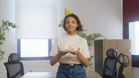 女孩拿着生日蛋糕看着镜头的肖像