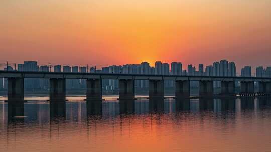 黄昏日落下的高铁跨江大桥延时