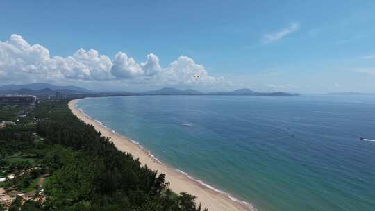 航拍三亚海棠湾蓝天白云动力伞直升机海岸线