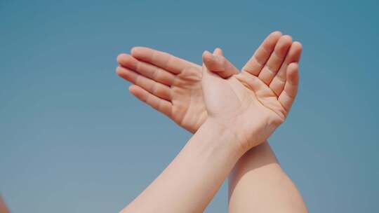 蓝天下双手和平鸽手势 手指交叉向上