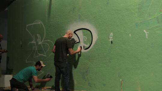 涂鸦者在墙上喷涂涂鸦的延时镜头
