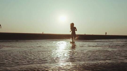 一个女人赤脚在海滩上跑步