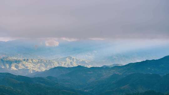 桂林资源县阳光透过云层照在山丘上延时摄影