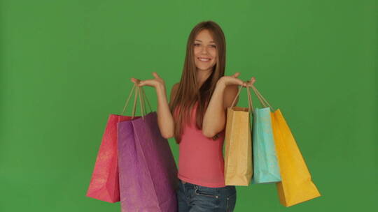 女孩提着购物袋在镜头前摆姿势视频素材模板下载