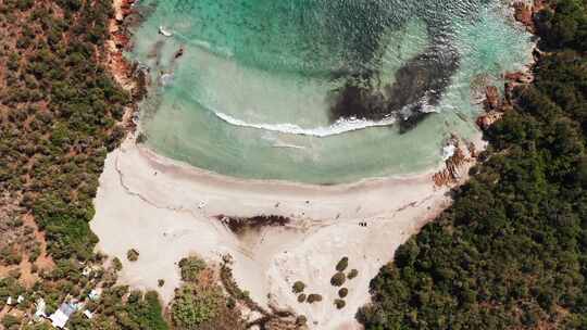 鸟瞰白沙滩蓝海海洋植被波浪堤和红岩