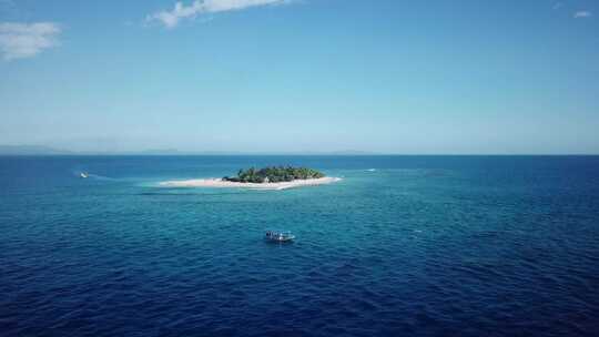 无人机射击，从远处飞向斐济以南海岛为背景的一艘船