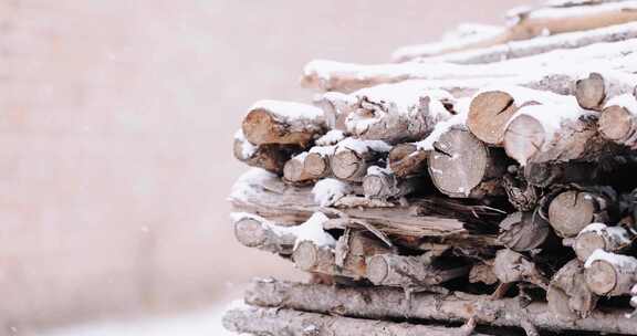 冬天北方下大雪中的木头干柴垛