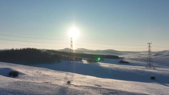 冬季大兴安岭丘陵地带雪原夕阳输电线路