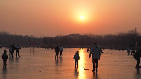 夕阳下冰面滑冰的游客人群