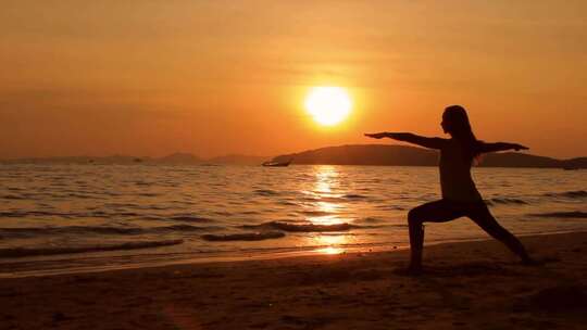 女子日落海滩练习瑜伽