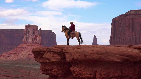 犹他州纪念碑谷的岩石上骑马的人