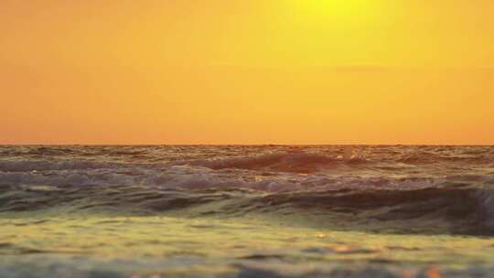 夕阳下金色海面浪花