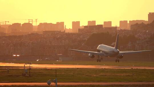 一架飞机降落在洒满金色阳光的机场跑道上