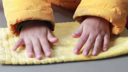 儿童用双手按压毛巾让毛巾吸水 幼儿手工