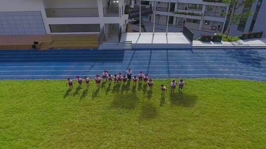 深圳龙华鹭湖外国语小学足球场上奔跑的学生