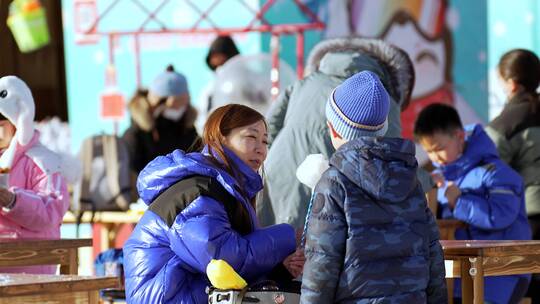 4K升格实拍冬季在冰雪乐园露天吃小吃的游人