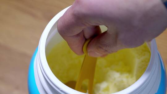 塑料罐里拿勺子舀取成人婴幼儿营养绿色奶粉视频素材模板下载