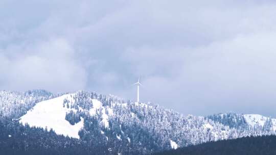 白雪覆盖的山顶上的风车