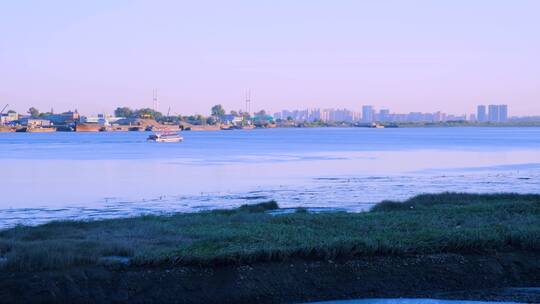 鸭绿江岸边朝鲜小镇与一艘航行江面的游船