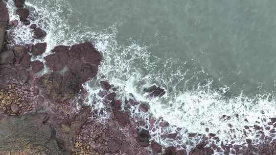 海岸礁石沙滩海水拍打礁石阴天海滩海浪冲刷