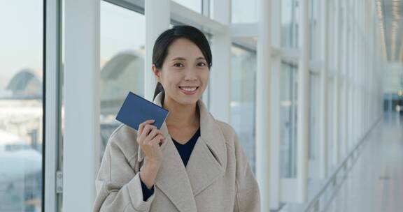 机场里拿着护照的快乐女人