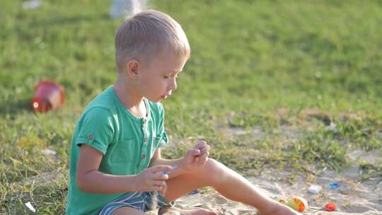 男孩在户外玩沙子玩具