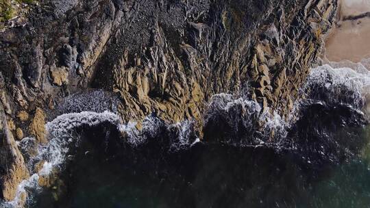 4K鸟瞰海岸波浪撞击岩石，慢动作。北爱尔视频素材模板下载