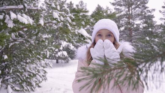 女孩戴着手套站在雪地里