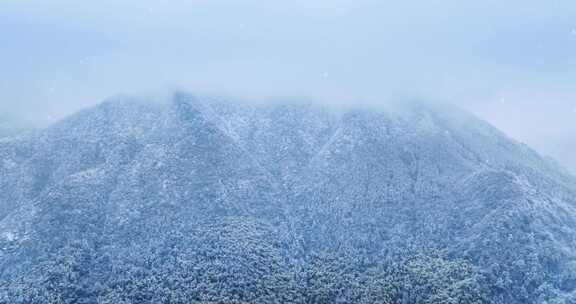 山峰雪景及森林云雾与雪花飘落的航拍延时