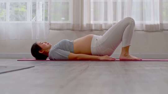 怀孕的女子在做瑜伽半桥