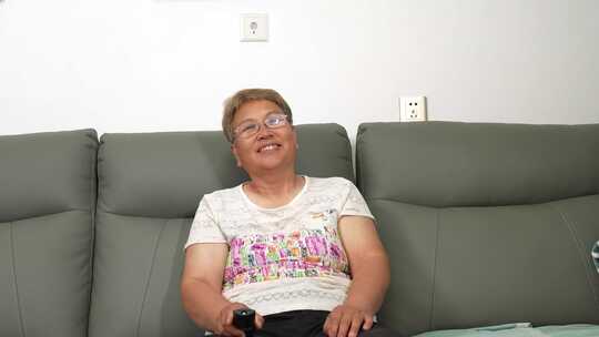 中老年女性沙发上手持遥控器