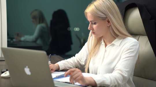 金发女性办公室使用笔记本电脑