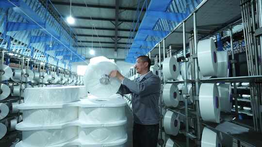 男性工人在化纤纺织厂车间工作