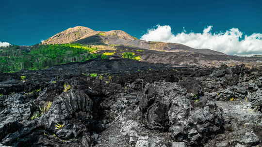 印度尼西亚巴厘岛巴图尔火山黑色熔岩的戏剧性景象。延时视频素材模板下载