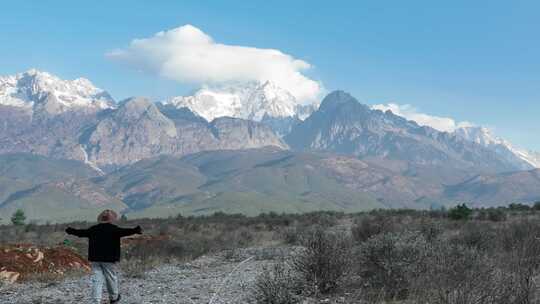 4k人在旷野张开双臂面对雪山感受风和自由