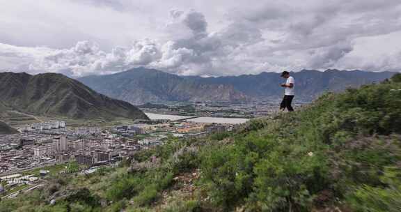 拉萨男子站在山巅航拍