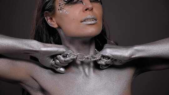 银色人体艺术和脖子上戴着链子的女模特在工