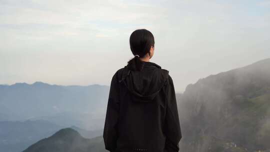 女性青年站在山顶看风景背影看远山感受自然视频素材模板下载