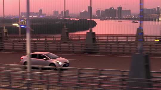 黄昏下的汽车行驶在跨江大桥上