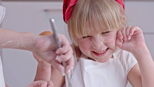 满脸面粉的小女孩在厨房帮忙