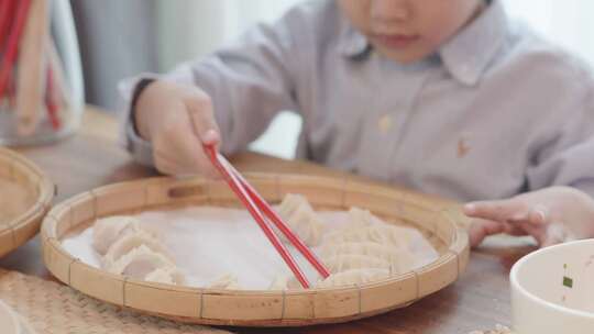 男孩用筷子吃饺子