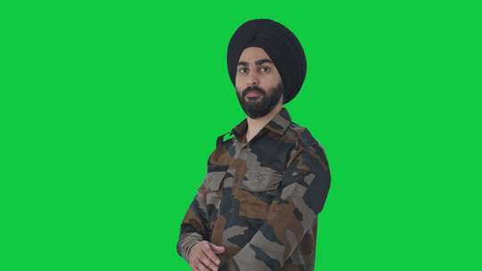 自信的锡克教印度军人双手交叉站立的肖像绿